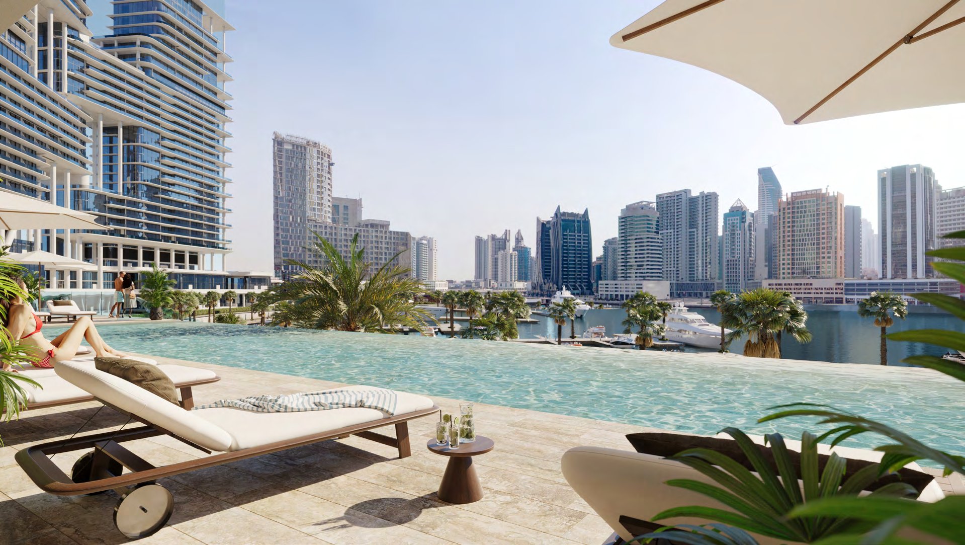 Infinity pool deck with loungers looking over the marina and towers