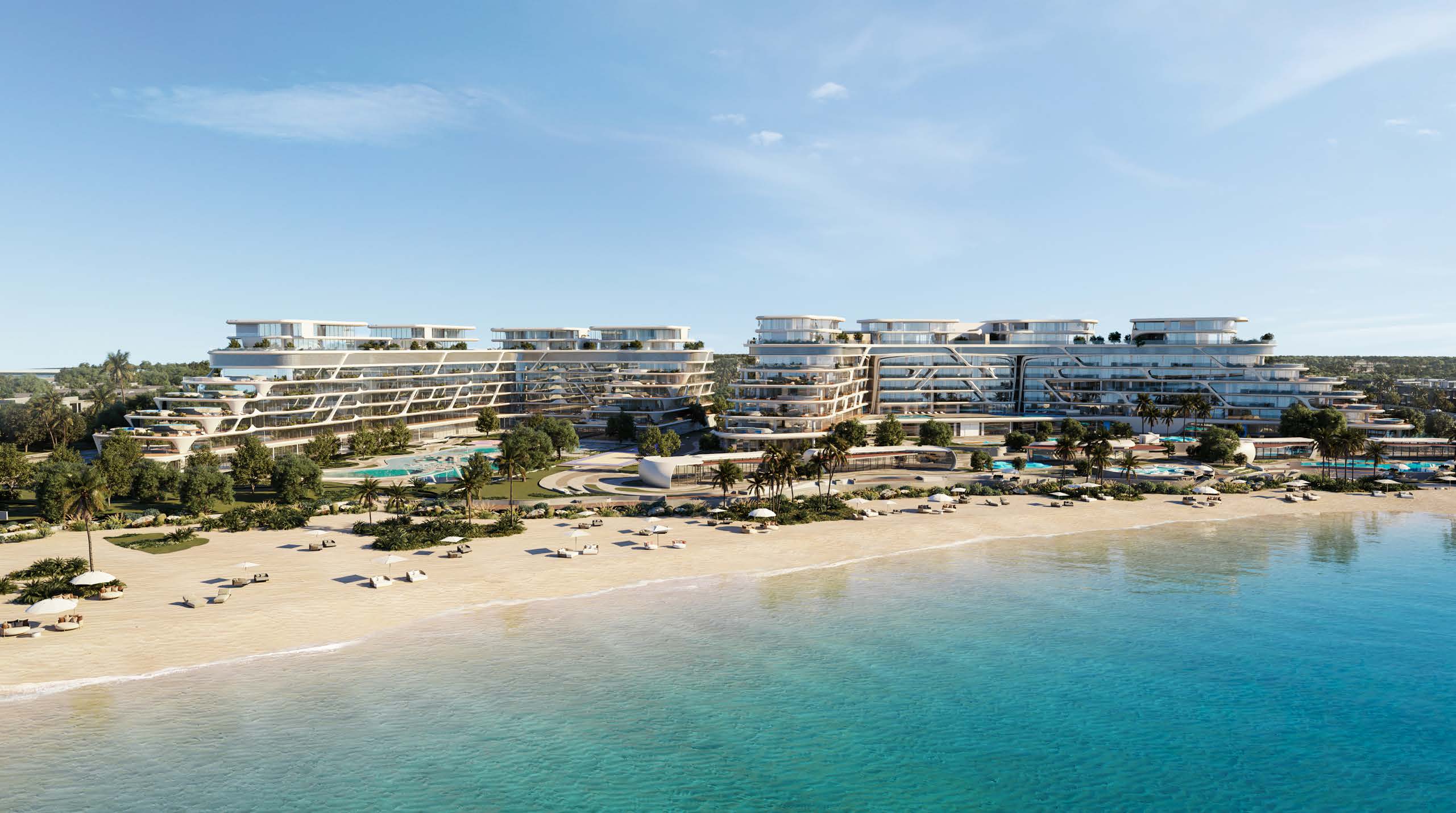 Curving terraced apartment buildings behind a sandy beach and turquoise sea