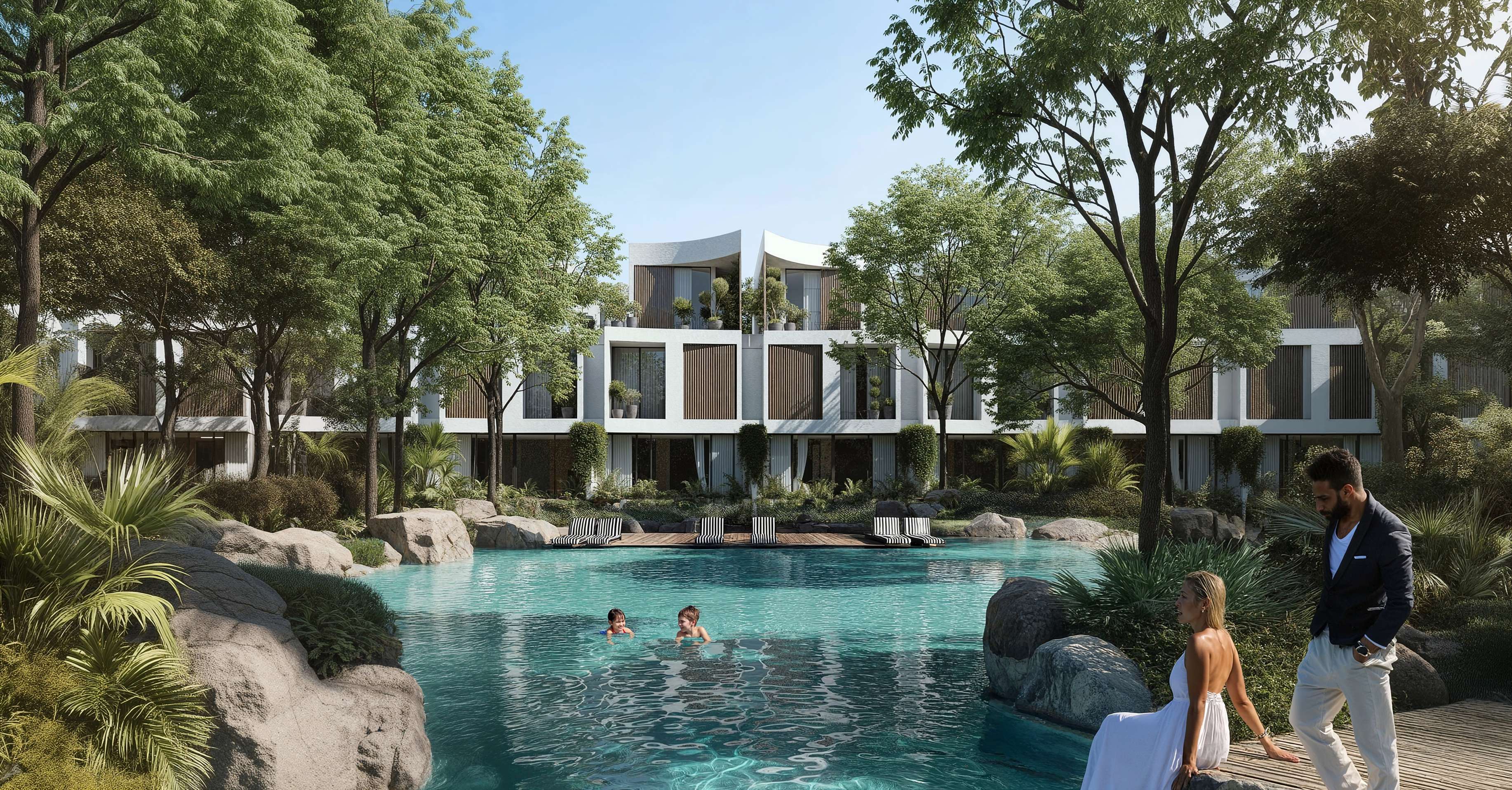 Children swimming in a rock-edged lagoon below terraced white homes