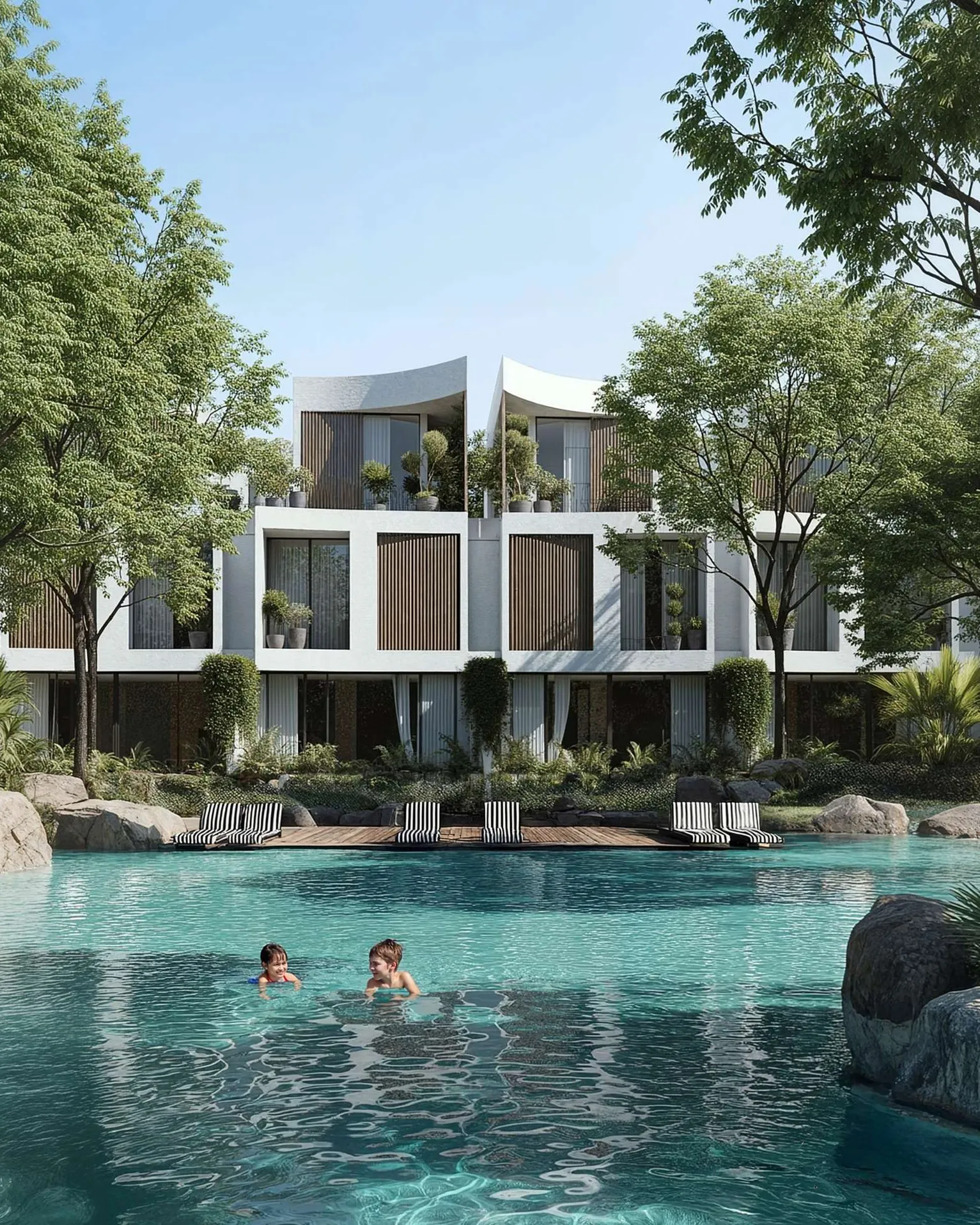 Children swimming in a rock-edged lagoon below terraced white homes