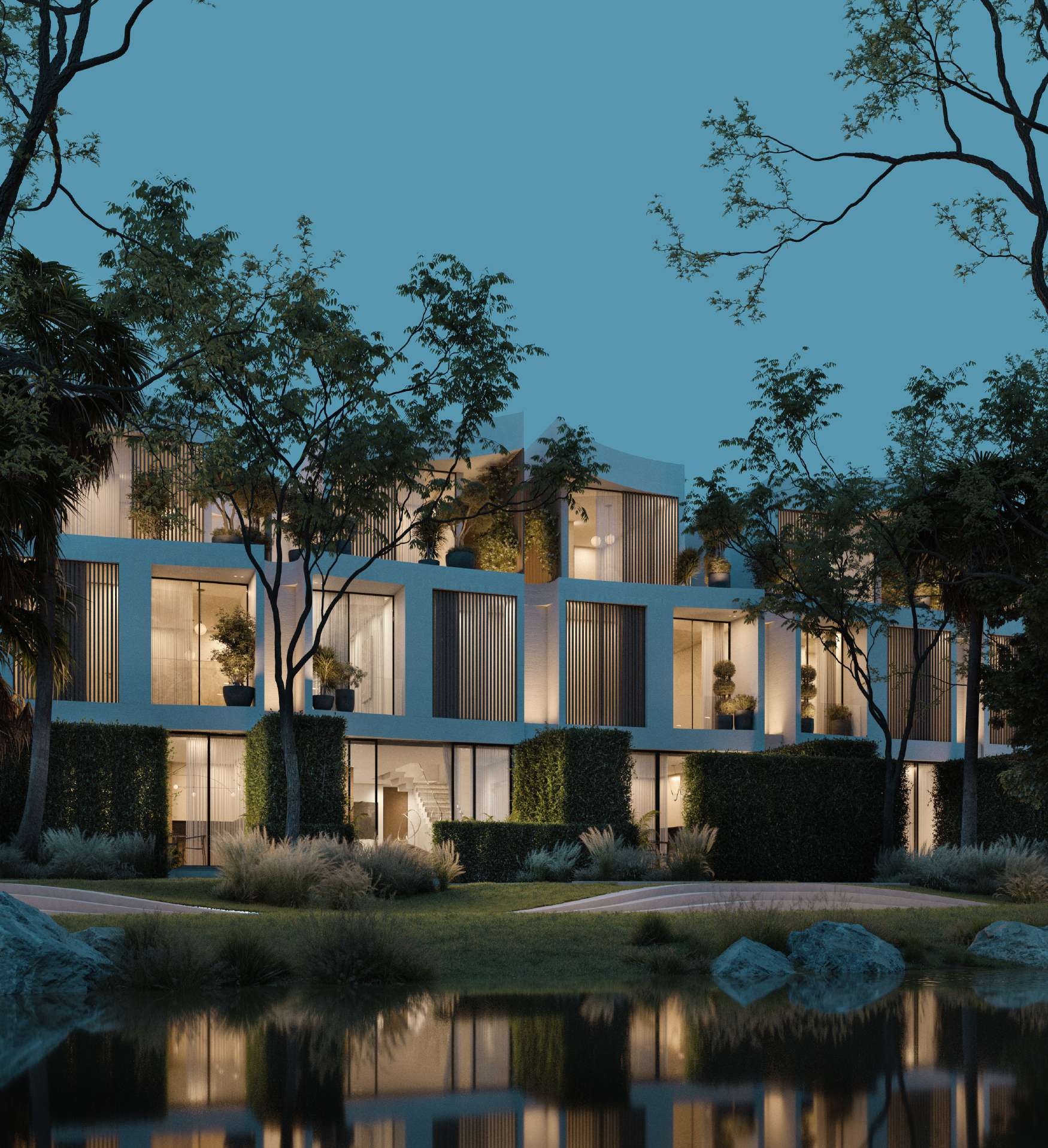 Bloom townhouses at twilight, warm windows reflected in still water