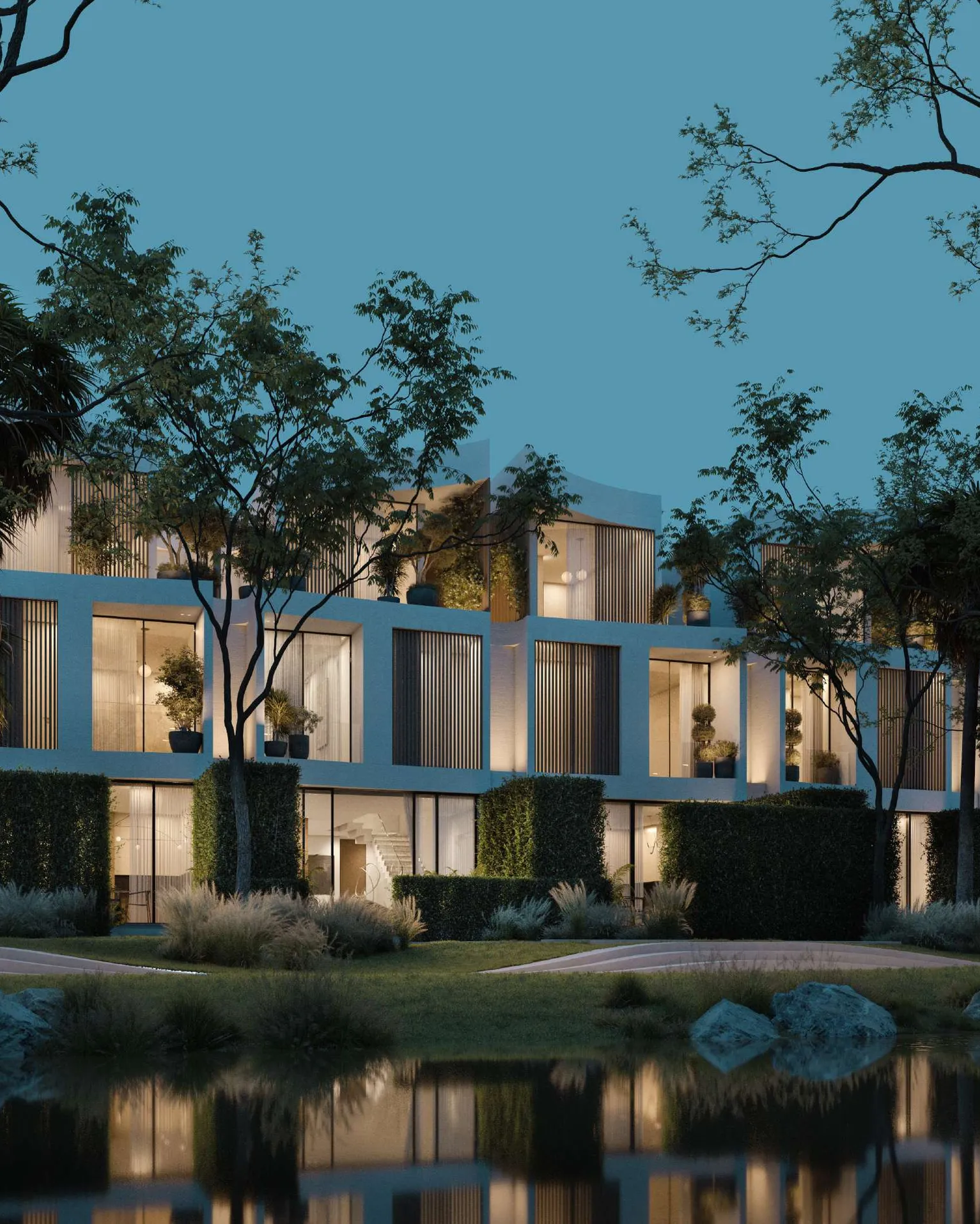Bloom townhouses at twilight, warm windows reflected in still water
