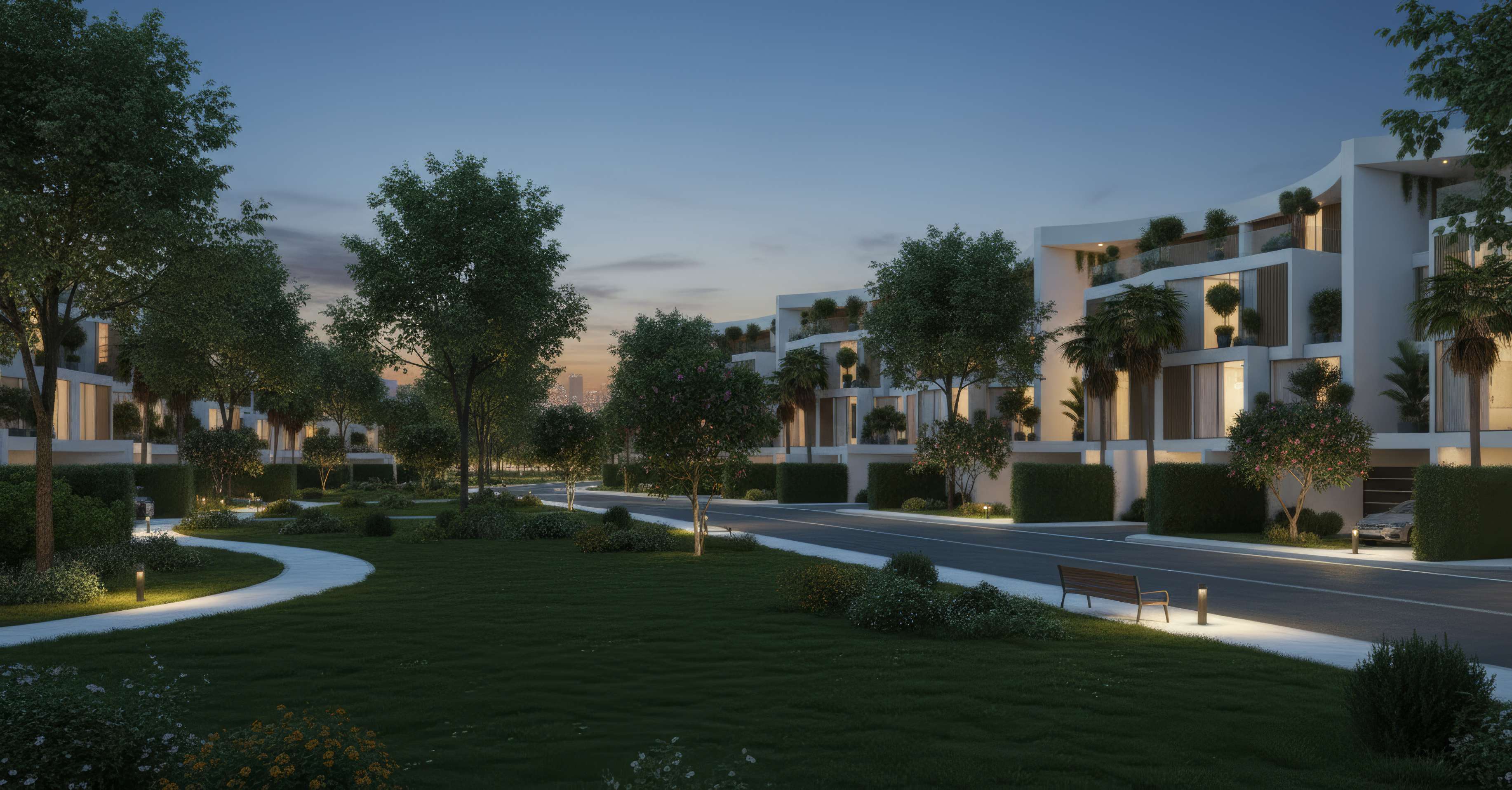 Tree-lined street and park between curved white villas at dusk