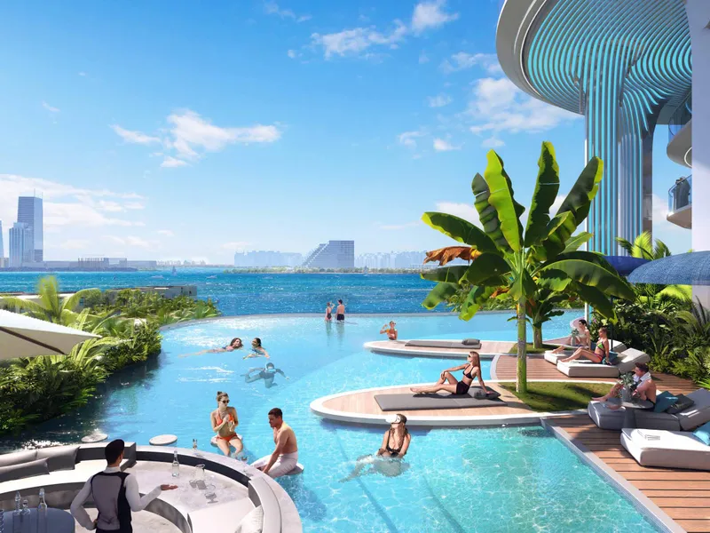 Infinity pool with sun loungers and palms, the sea and skyline beyond