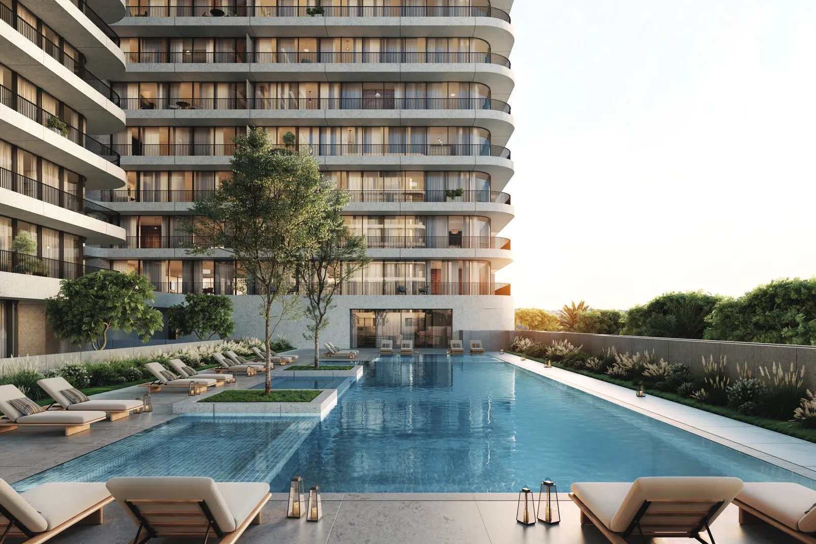 Long pool lined with sun loungers beneath a curved residential building