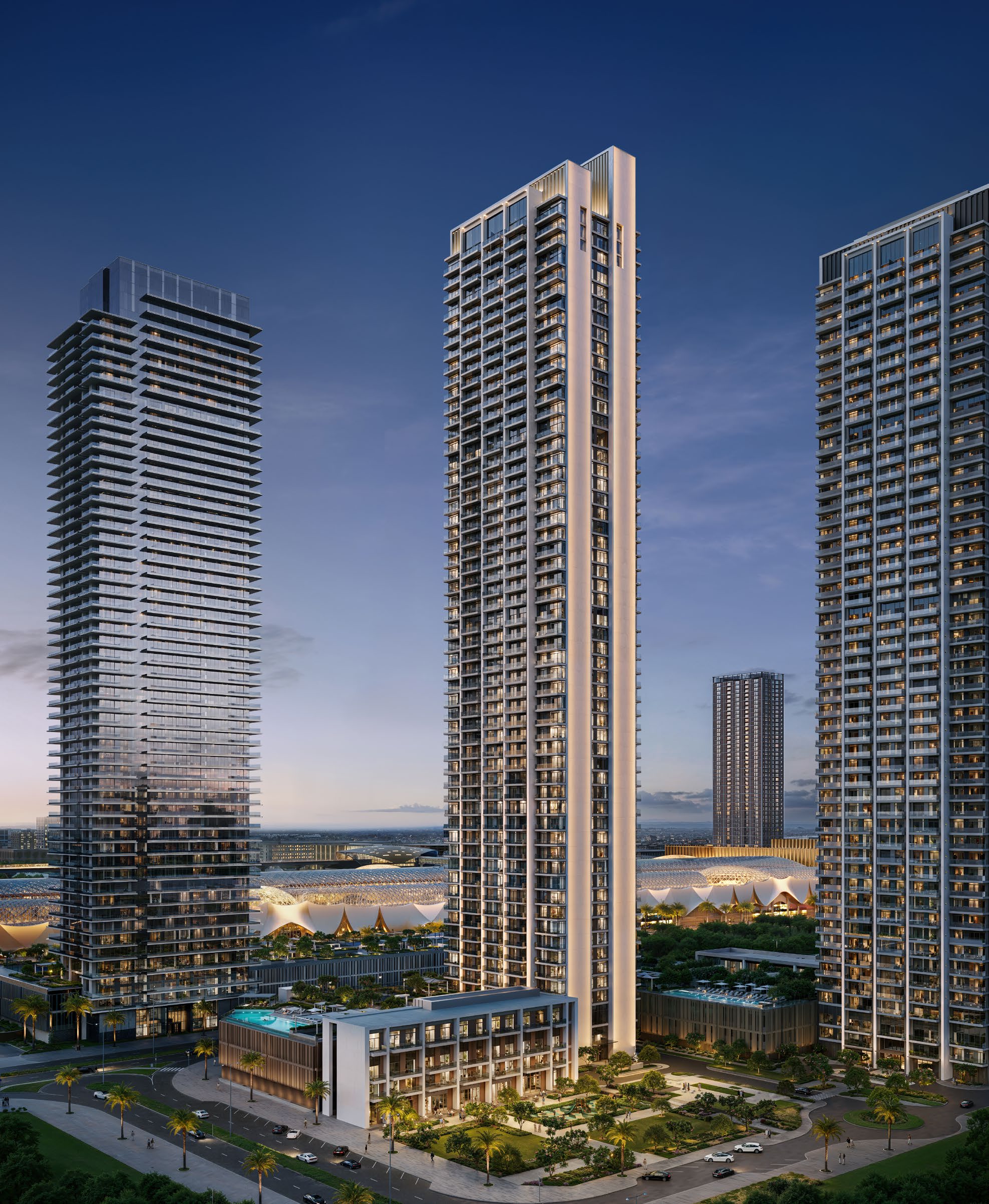 Valia's tall slender tower at dusk above its landscaped podium and pools