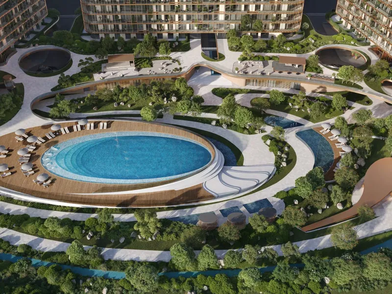 Aerial view of HADO's oval pool and gardens between three towers