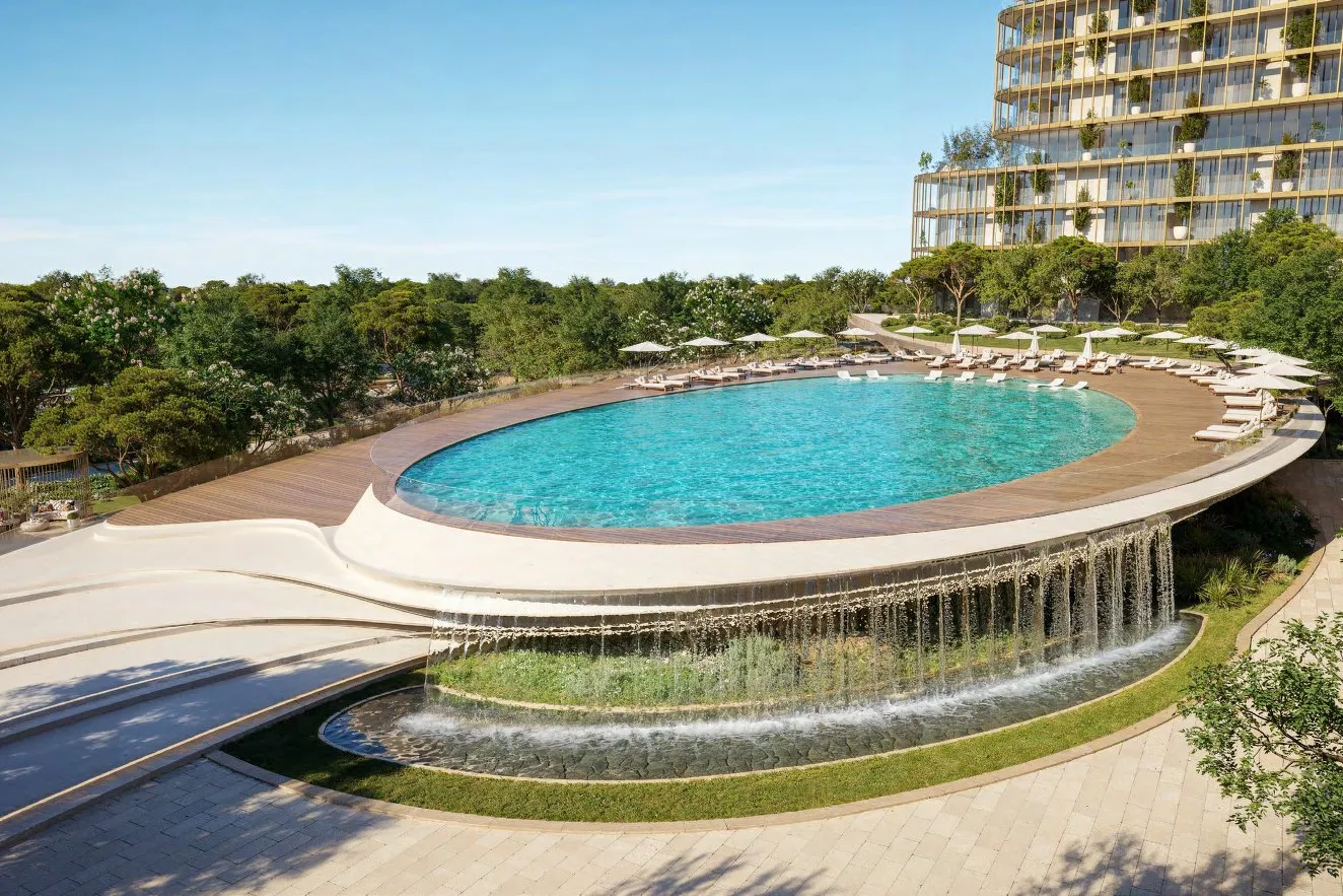Oval pool deck with loungers and a water cascade below its edge