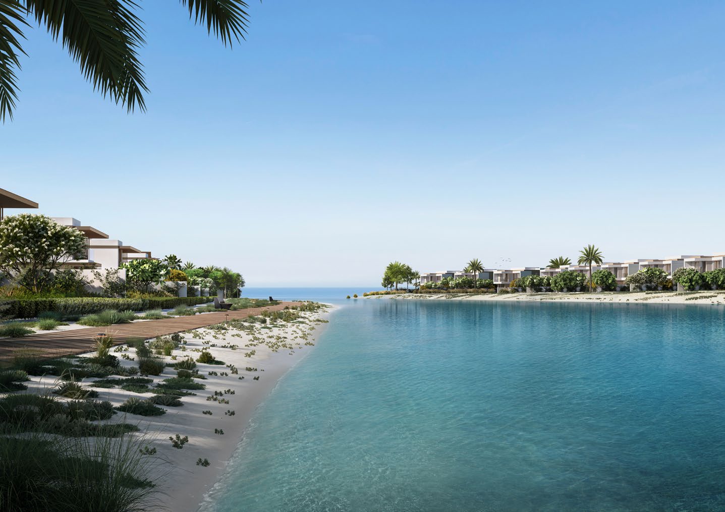 Calm canal with a sandy edge and boardwalk beside villas