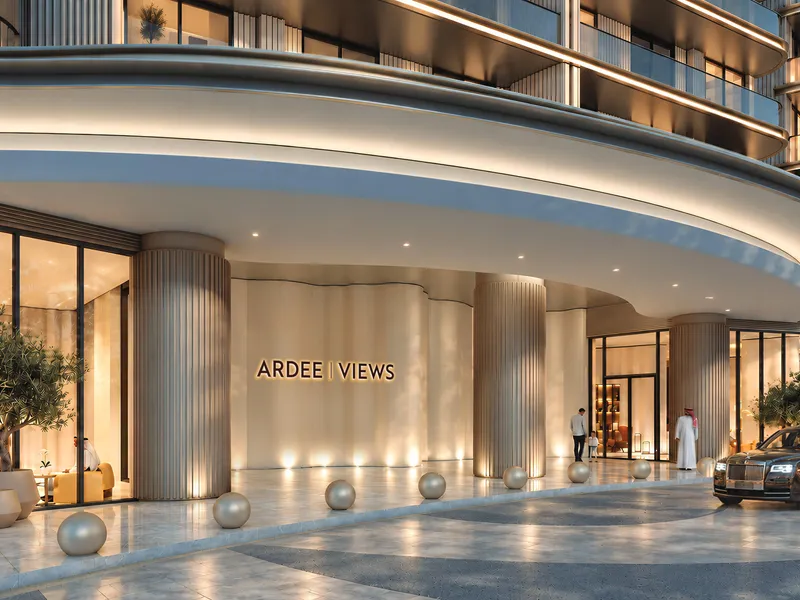 Curved, softly lit entrance canopy of Ardee Views with a car at the door