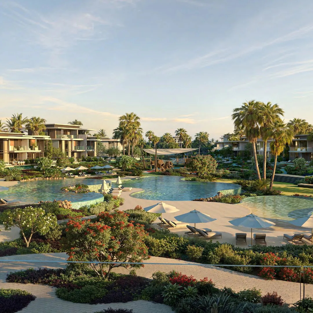 Shared pools with parasols and flowering gardens between the villas