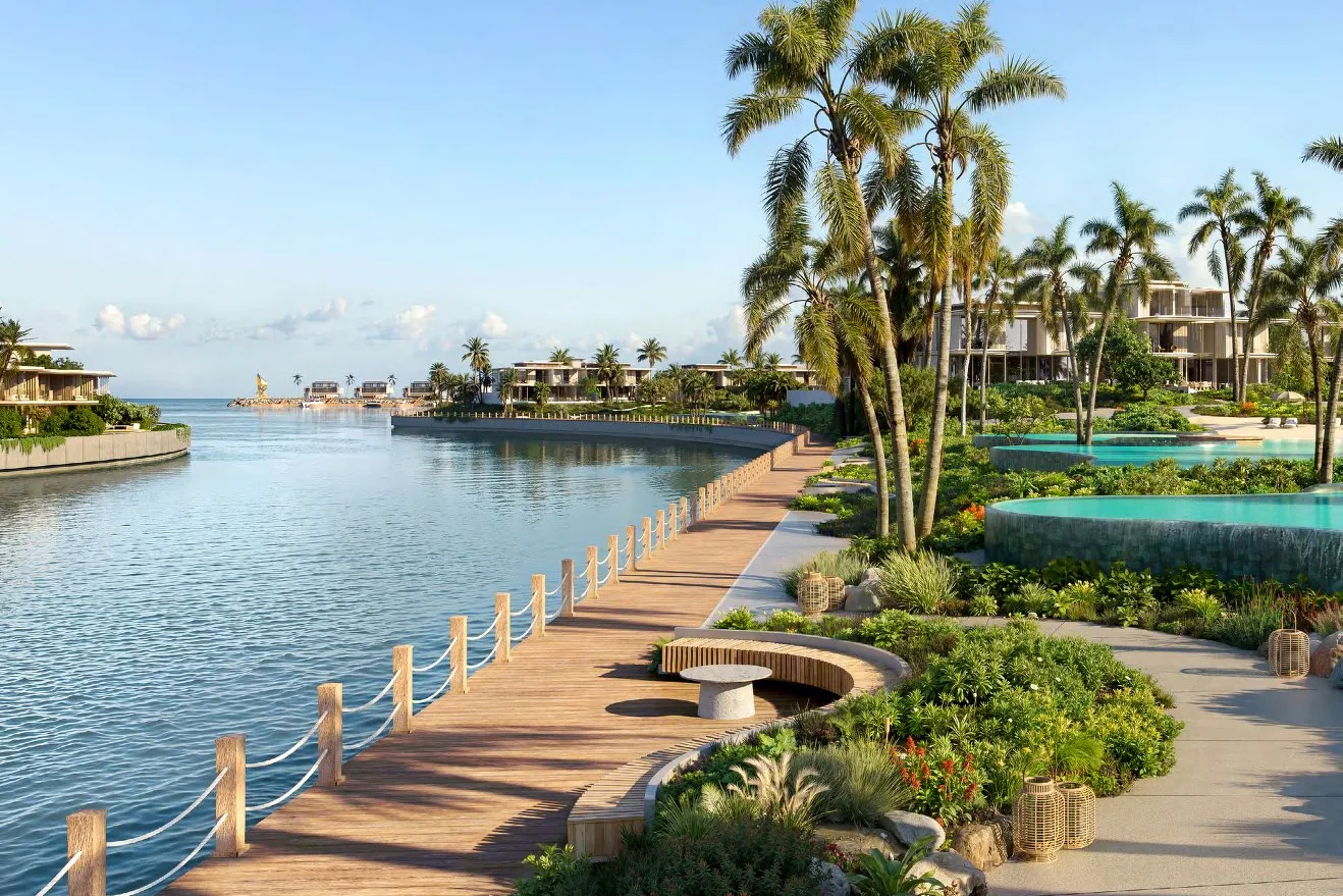 Timber promenade along the water with palms and villas beside it