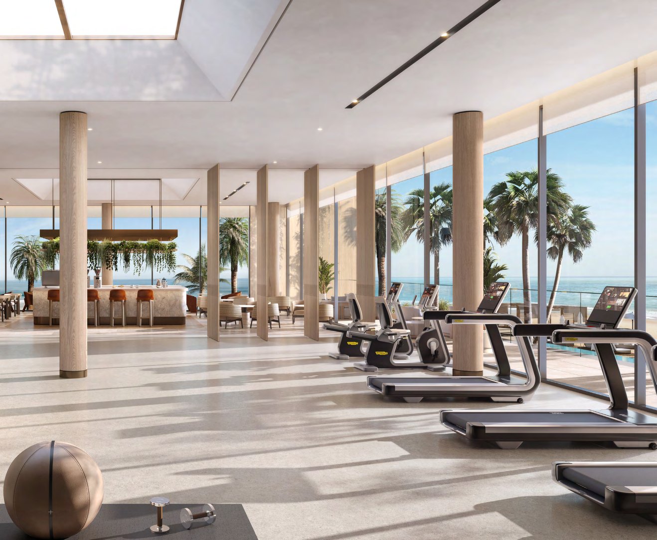 Bright gym with treadmills and a café bar facing the sea