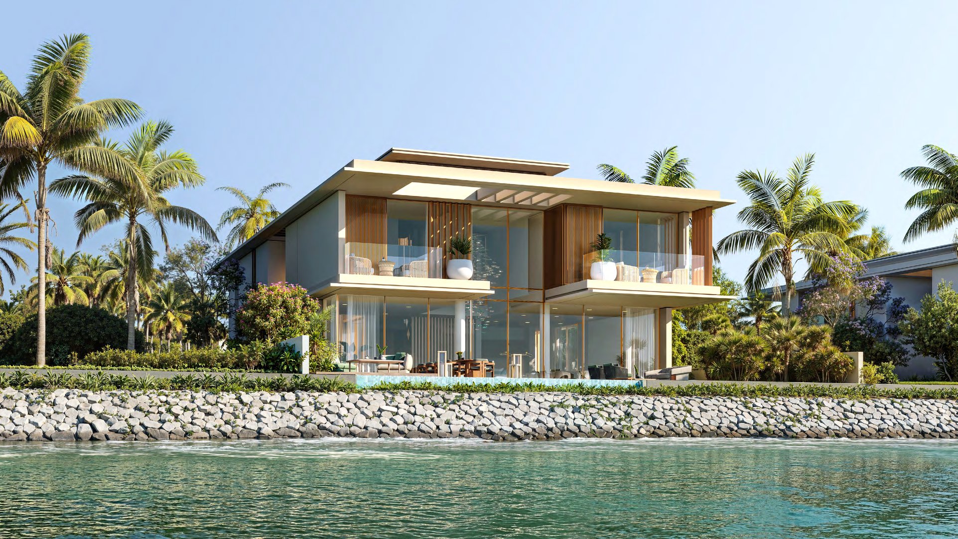 Reference design villa with balconies and pool above a rock-lined waterfront