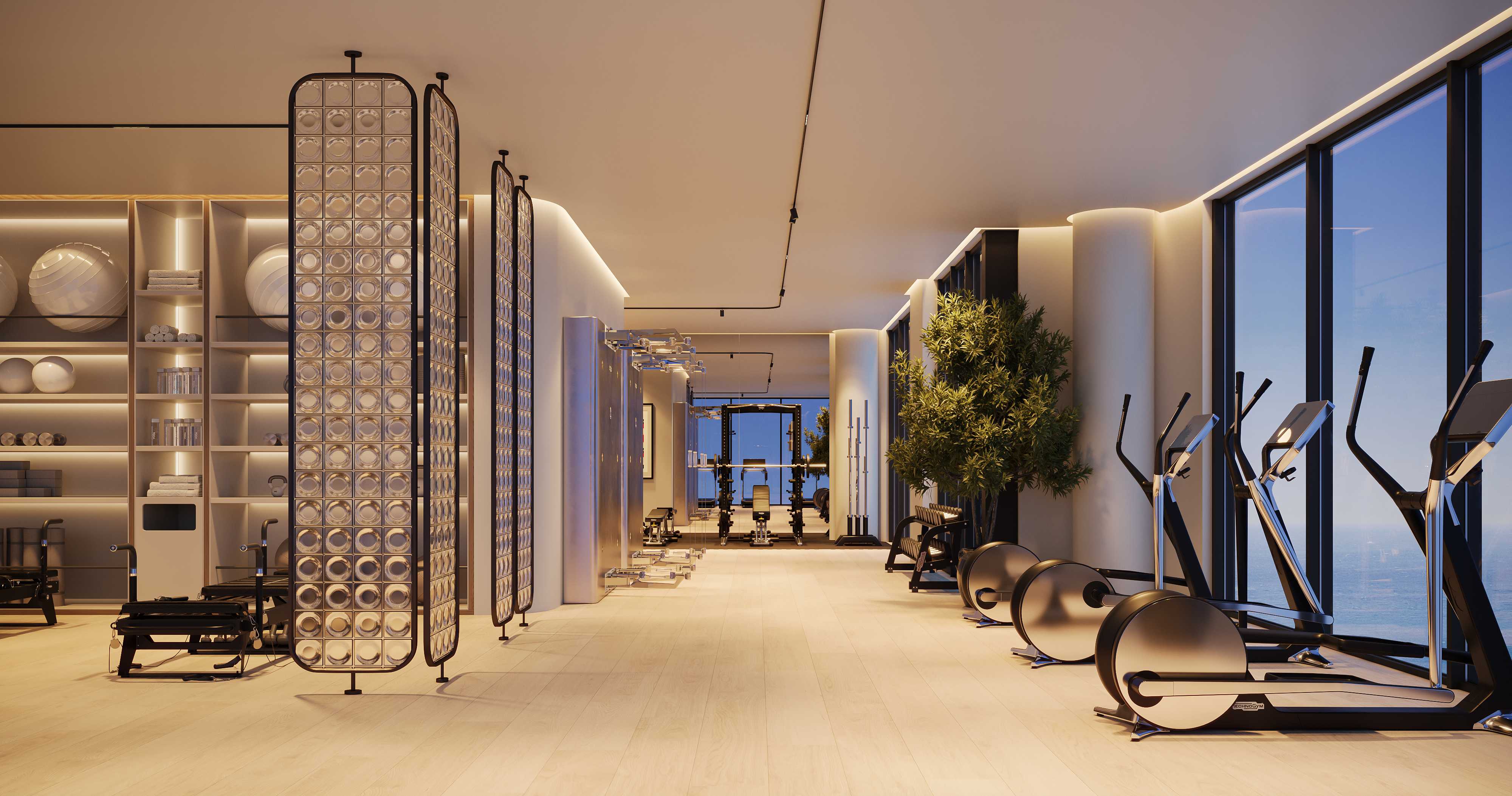 Fitness floor with Technogym machines and tall windows facing the sea
