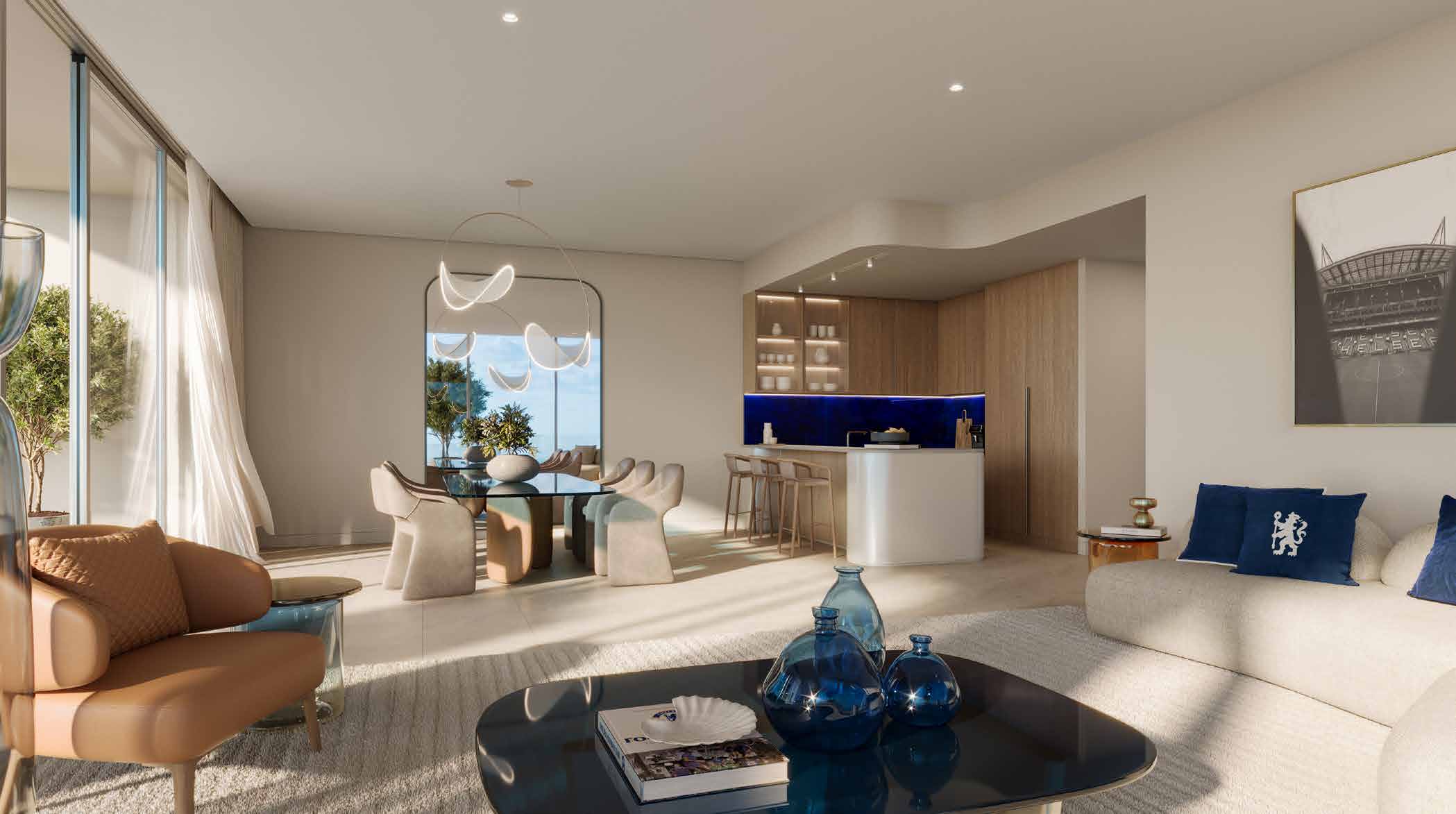 Living room opening to a kitchen with blue splashback and dining table