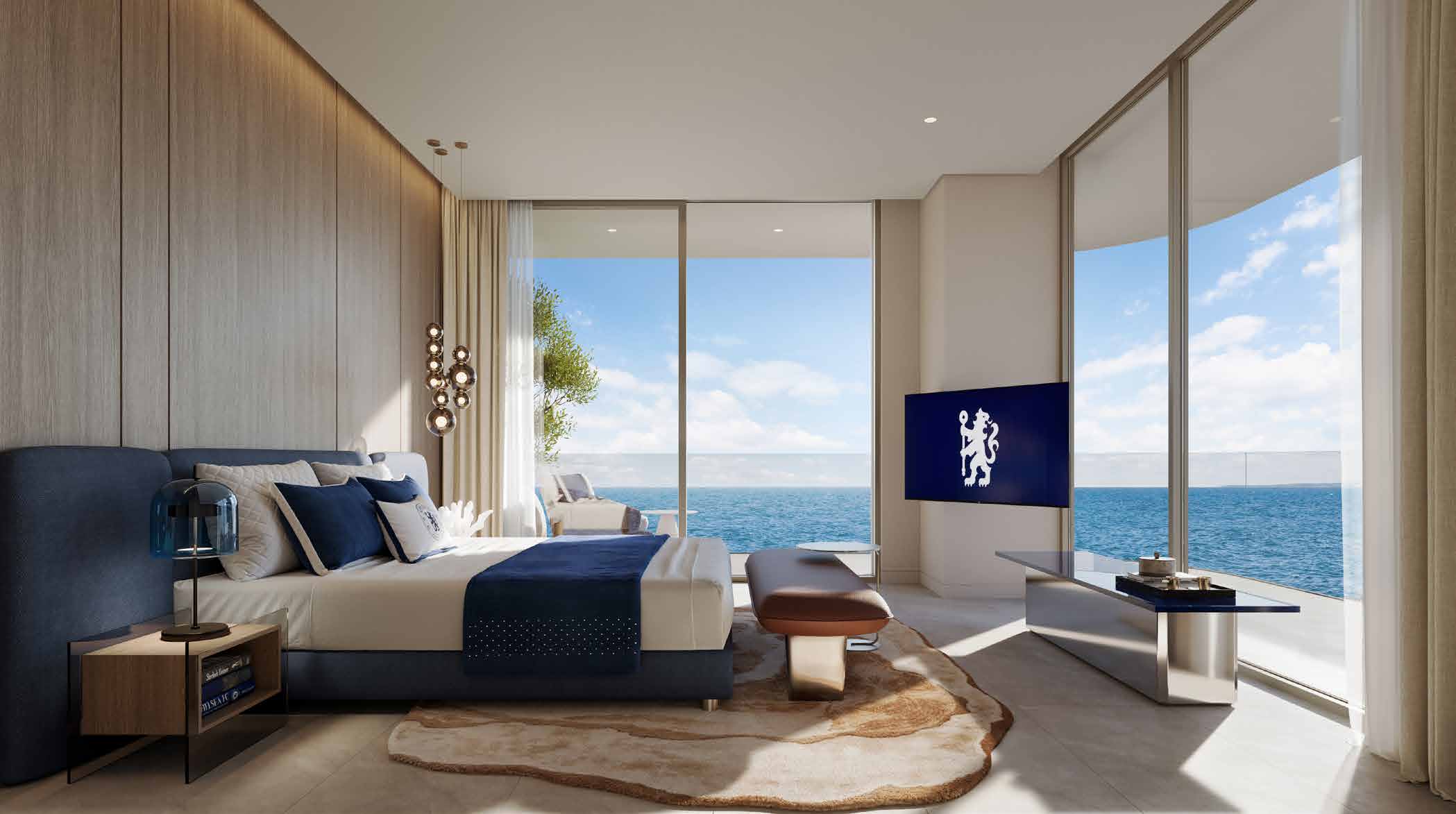 Bedroom with navy bed, corner windows and wide sea view