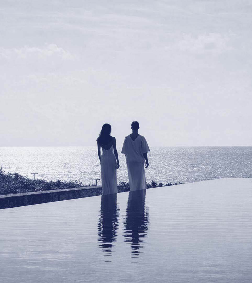 Two people at the edge of an infinity pool at dusk